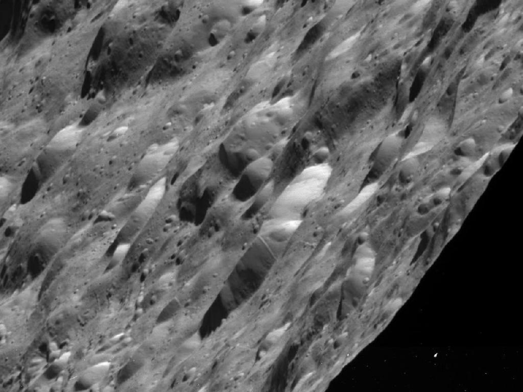New Photos of Saturn Moon Show a Pockmarked Place